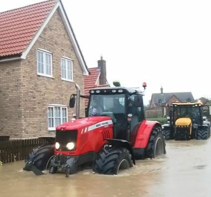 A tractor ferrying school pupils through floodwater in Debenham on Friday afternoon. Credit: Phil Mason